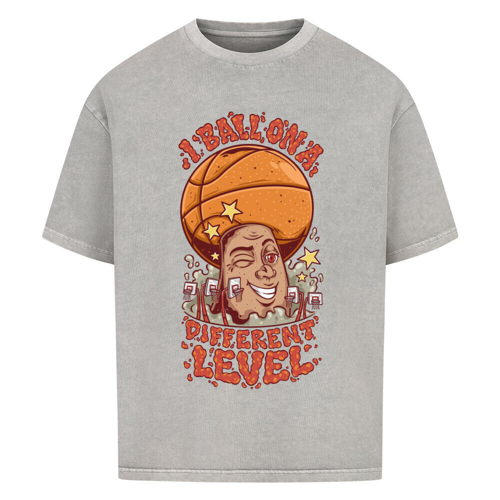 Washed Grey Oversized Basketball T-Shirt mit einem bunten Cartoon-Print einer zwinkernden Figur, die einen Basketball als Kopf hat. Der rote Text lautet „I BALL ON A DIFFERENT LEVEL“. 100% Baumwolle
