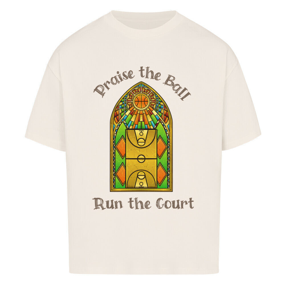 Natural Raw Oversized Basketball T-Shirt mit einem Print im Stil eines Kirchen-Buntglasfensters, der einen Basketball-Court zeigt. Darüber steht „Praise the Ball“ und darunter „Run the Court“ in einer gotischen Schriftart. 100% Baumwolle 