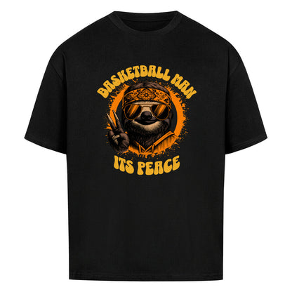 Schwarzes Oversized Basketball T-Shirt mit einem 70er-Jahre-Retro-Print eines coolen Faultiers (Sloth) mit Sonnenbrille und Bandana, das ein Peace-Zeichen macht. Der Text lautet „BASKETBALL MAN“ und „ITS PEACE“ in Orange und Gelb. 100% Baumwolle.