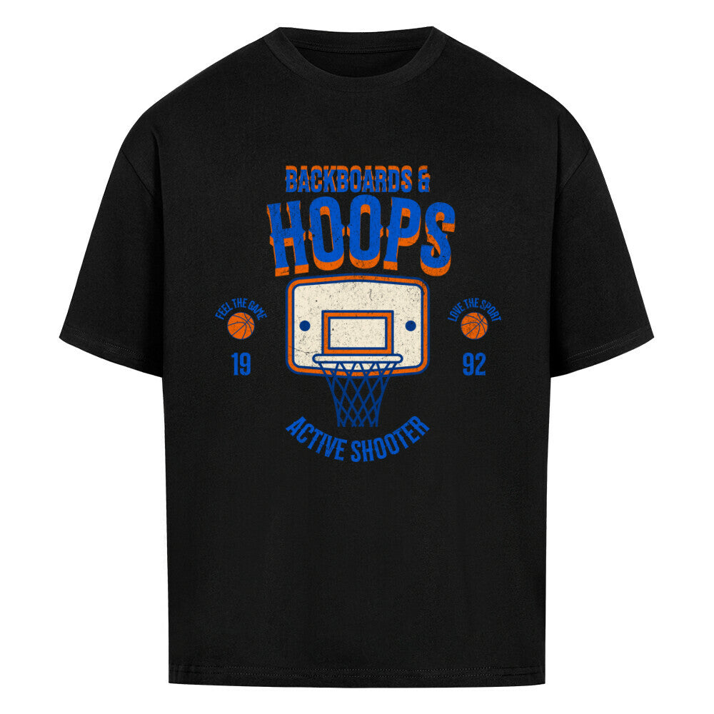 Schwarzes Oversized T-Shirt mit Retro-Print eines Basketballkorbs, dem Text „BACKBOARDS & HOOPS“ und dem Geburtsjahr „19 92“ in Orange und Blau. 100% Baumwolle