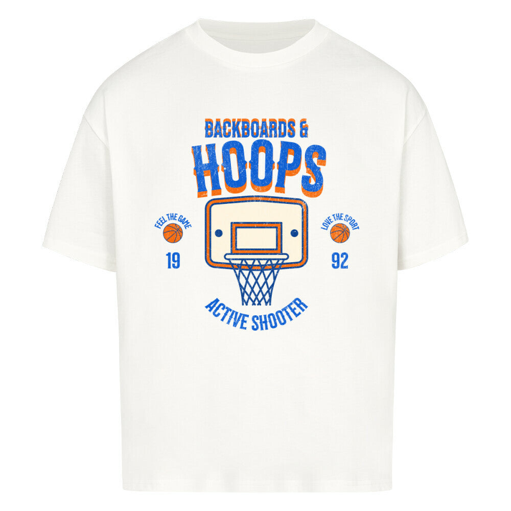 Weißes Oversized T-Shirt mit Retro-Print eines Basketballkorbs, dem Text „BACKBOARDS & HOOPS“ und dem Geburtsjahr „19 92“ in Orange und Blau. 100% Baumwolle