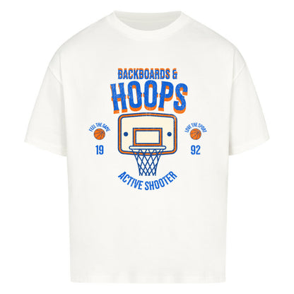 Weißes Oversized T-Shirt mit Retro-Print eines Basketballkorbs, dem Text „BACKBOARDS & HOOPS“ und dem Geburtsjahr „19 92“ in Orange und Blau. 100% Baumwolle