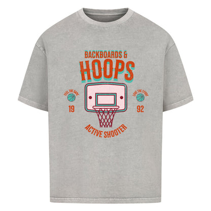 Washed Grey Oversized T-Shirt mit 90er-Jahre-Retro-Print eines Basketballkorbs und den Schriftzügen „BACKBOARDS & HOOPS“, „ACTIVE SHOOTER“ und „19 92“ in Orange und Türkis. 100% Baumwolle.