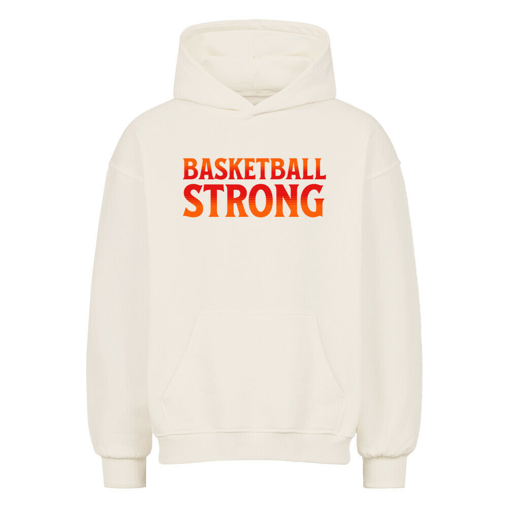 Vorderansicht eines cremefarbenen Oversized-Hoodies mit dem Aufdruck 'BASKETBALL STRONG' in einer rot-orangen Farbverlaufsschrift auf der Brust. 80% Baumwolle 20% Polyester.