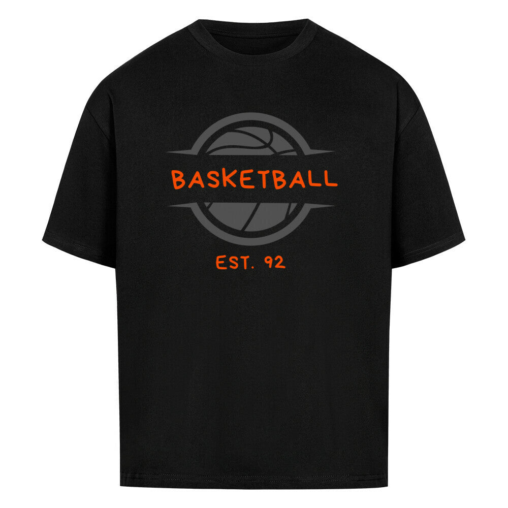Schwarzes Oversized T-Shirt mit einem Print eines grauen Basketball-Emblems und dem orangefarbenen, stilisierten Text „BASKETBALL“ und „EST. 92“. 100% Baumwolle.