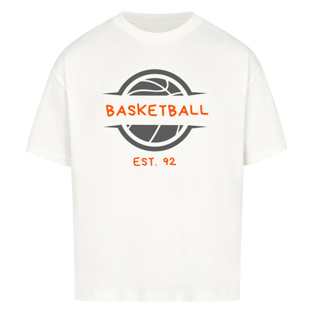 Weißes Oversized T-Shirt mit einem Print eines grauen Basketball-Emblems und dem orangefarbenen, stilisierten Text „BASKETBALL“ und „EST. 92“. 100% Baumwolle.