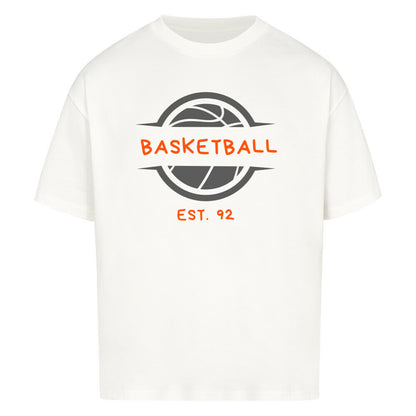 Weißes Oversized T-Shirt mit einem Print eines grauen Basketball-Emblems und dem orangefarbenen, stilisierten Text „BASKETBALL“ und „EST. 92“. 100% Baumwolle.