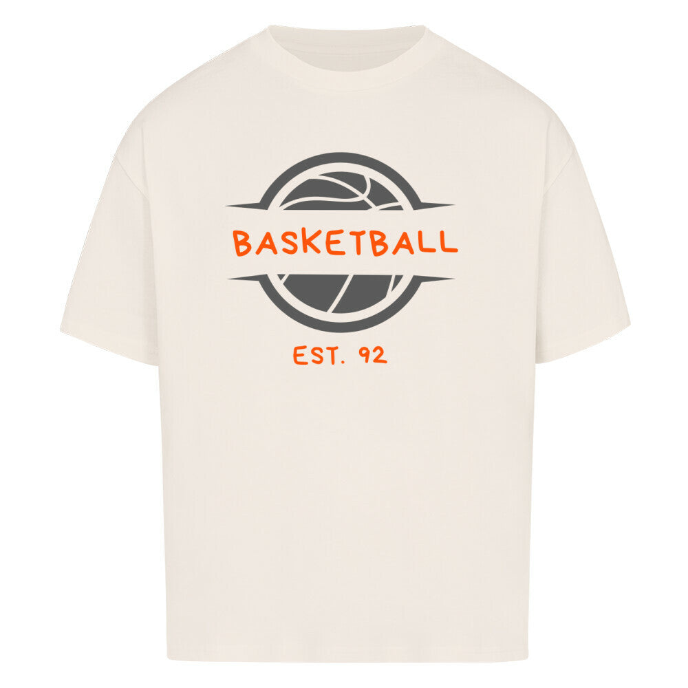 Natural Raw Oversized T-Shirt mit einem Print eines grauen Basketball-Emblems und dem orangefarbenen, stilisierten Text „BASKETBALL“ und „EST. 92“. 100% Baumwolle.