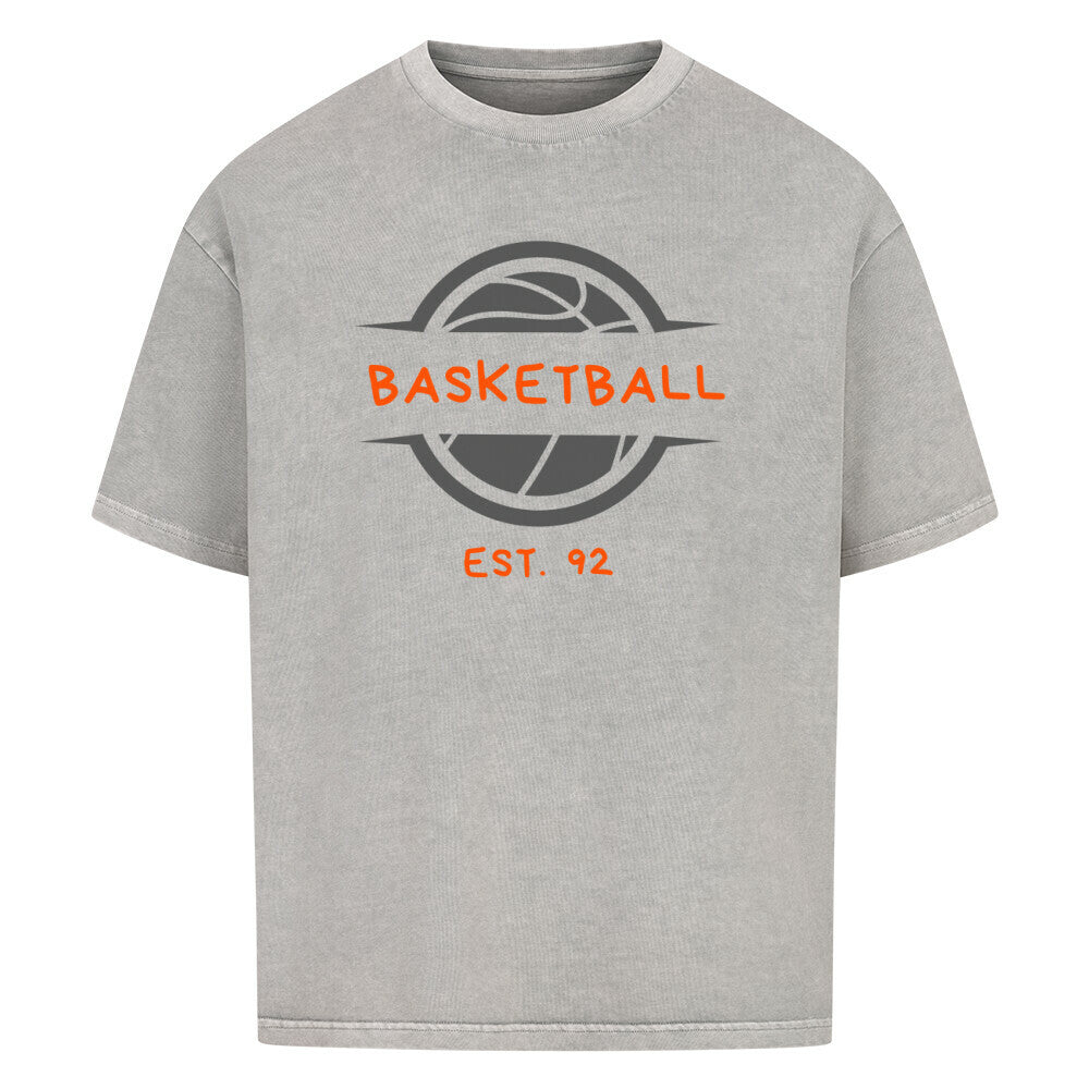 Washed Grey Oversized T-Shirt mit einem Print eines grauen Basketball-Emblems und dem orangefarbenen, stilisierten Text „BASKETBALL“ und „EST. 92“. 100% Baumwolle.