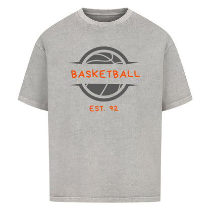 Washed Grey Oversized T-Shirt mit einem Print eines grauen Basketball-Emblems und dem orangefarbenen, stilisierten Text „BASKETBALL“ und „EST. 92“. 100% Baumwolle.