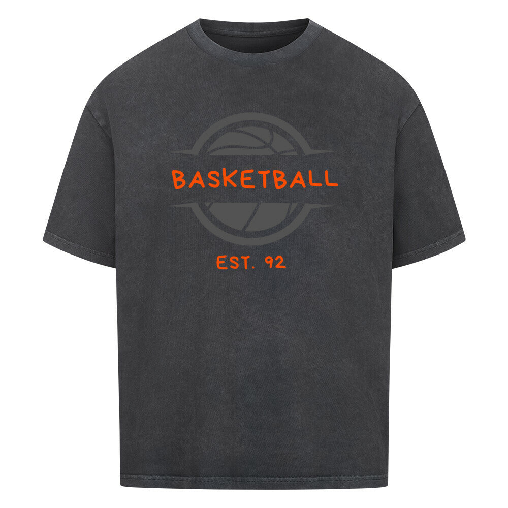 Washed Schwarzes Oversized T-Shirt mit einem Print eines grauen Basketball-Emblems und dem orangefarbenen, stilisierten Text „BASKETBALL“ und „EST. 92“. 100% Baumwolle.