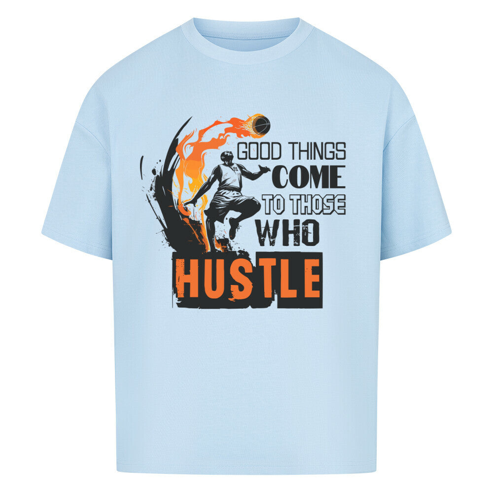 Babyblaues Oversized T-Shirt mit einem schwarz-orangen Print eines Basketballspielers in Flammen und dem motivierenden Spruch „GOOD THINGS COME TO THOSE WHO HUSTLE“. 100% Baumwolle.
