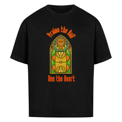 Schwarzes Oversized T-Shirt mit einem Print im Stil eines Kirchen-Buntglasfensters, der einen Basketball-Court zeigt. Darüber steht in Rot „Praise the Ball“ und darunter „Run the Court“. 100% Baumwolle.