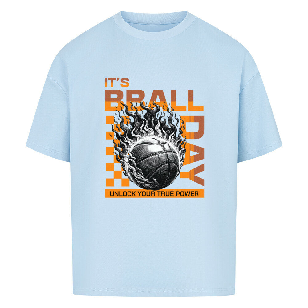 Babyblaues Oversized T-Shirt mit einem Print eines brennenden Basketballs (Ball on Fire) und dem orangefarbenen Text „IT'S BBALL DAY“ und „UNLOCK YOUR TRUE POWER“. 100% Baumwolle.