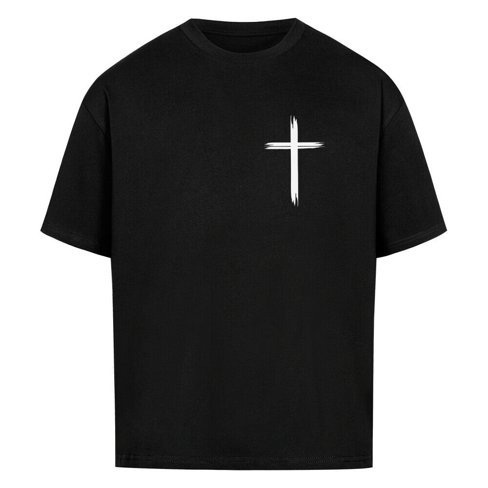 Vorderseite eines schwarzen Oversized T-Shirts mit einem kleinen, weißen, stilisierten Pinselstrich-Kreuz auf der linken Brust. 100% Bauwolle