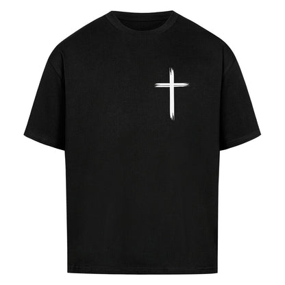 Vorderseite eines schwarzen Oversized T-Shirts mit einem kleinen, weißen, stilisierten Pinselstrich-Kreuz auf der linken Brust. 100% Bauwolle