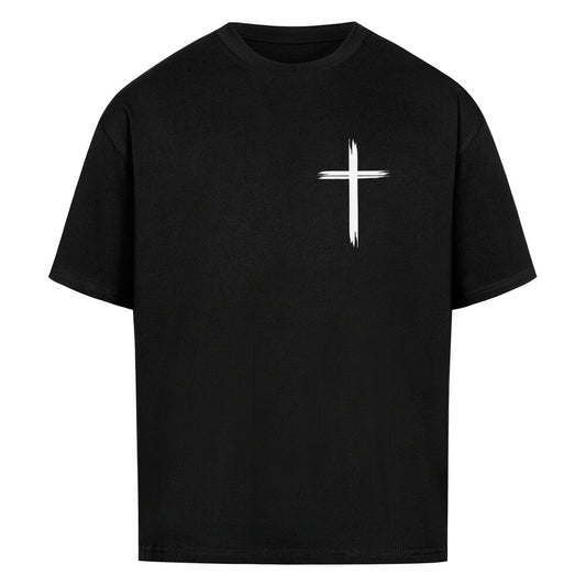 Vorderseite eines schwarzen Oversized T-Shirts mit einem kleinen, weißen, stilisierten Pinselstrich-Kreuz auf der linken Brust. 100% Bauwolle