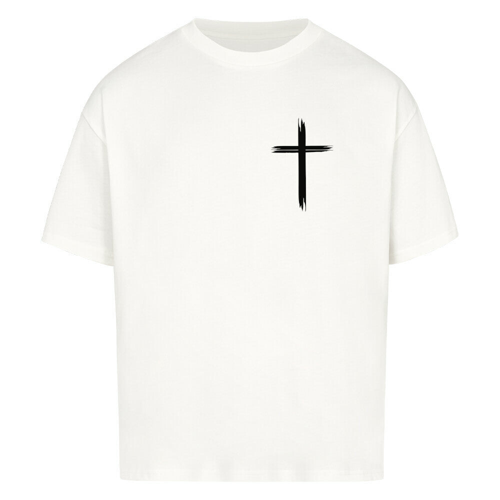 Vorderseite eines weißen Oversized T-Shirts mit einem kleinen, schwarzen, stilisierten Pinselstrich-Kreuz auf der linken Brust. 100% Baumwolle