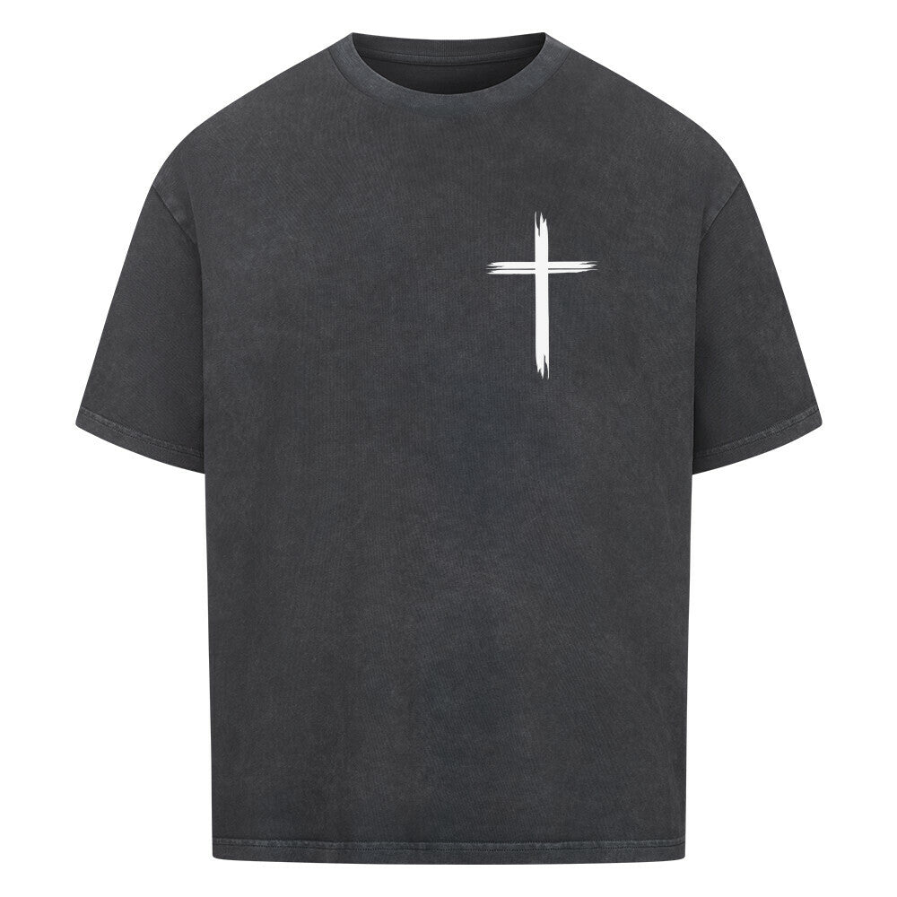 Vorderseite eines washed schwarzen Oversized T-Shirts mit einem kleinen, weißen, stilisierten Pinselstrich-Kreuz auf der linken Brust. 100% Baumwolle