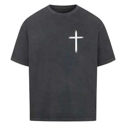 Vorderseite eines washed schwarzen Oversized T-Shirts mit einem kleinen, weißen, stilisierten Pinselstrich-Kreuz auf der linken Brust. 100% Baumwolle