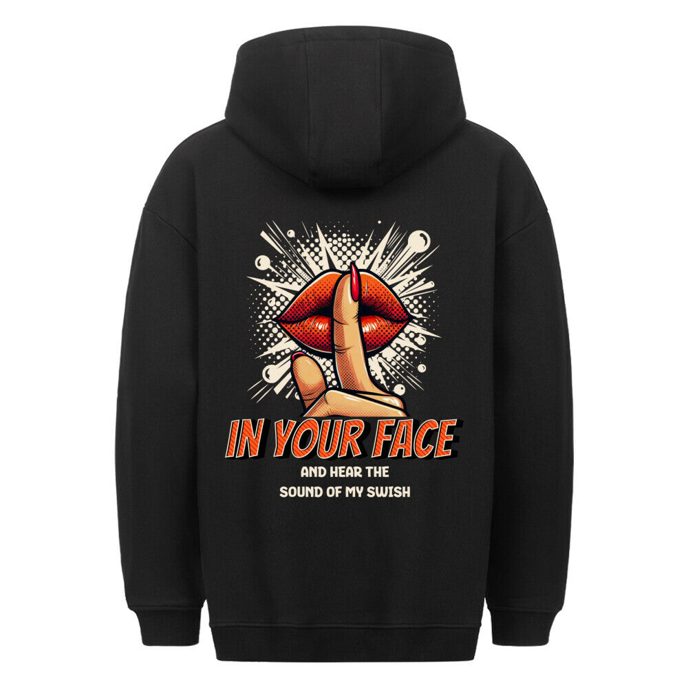 Rückansicht eines schwarzen Oversized-Hoodies mit Pop-Art-Print von roten Lippen und einem 'Shh'-Finger, mit dem Spruch 'IN YOUR FACE AND HEAR THE SOUND OF MY SWISH'. 80% Baumwolle 20% Polyester.