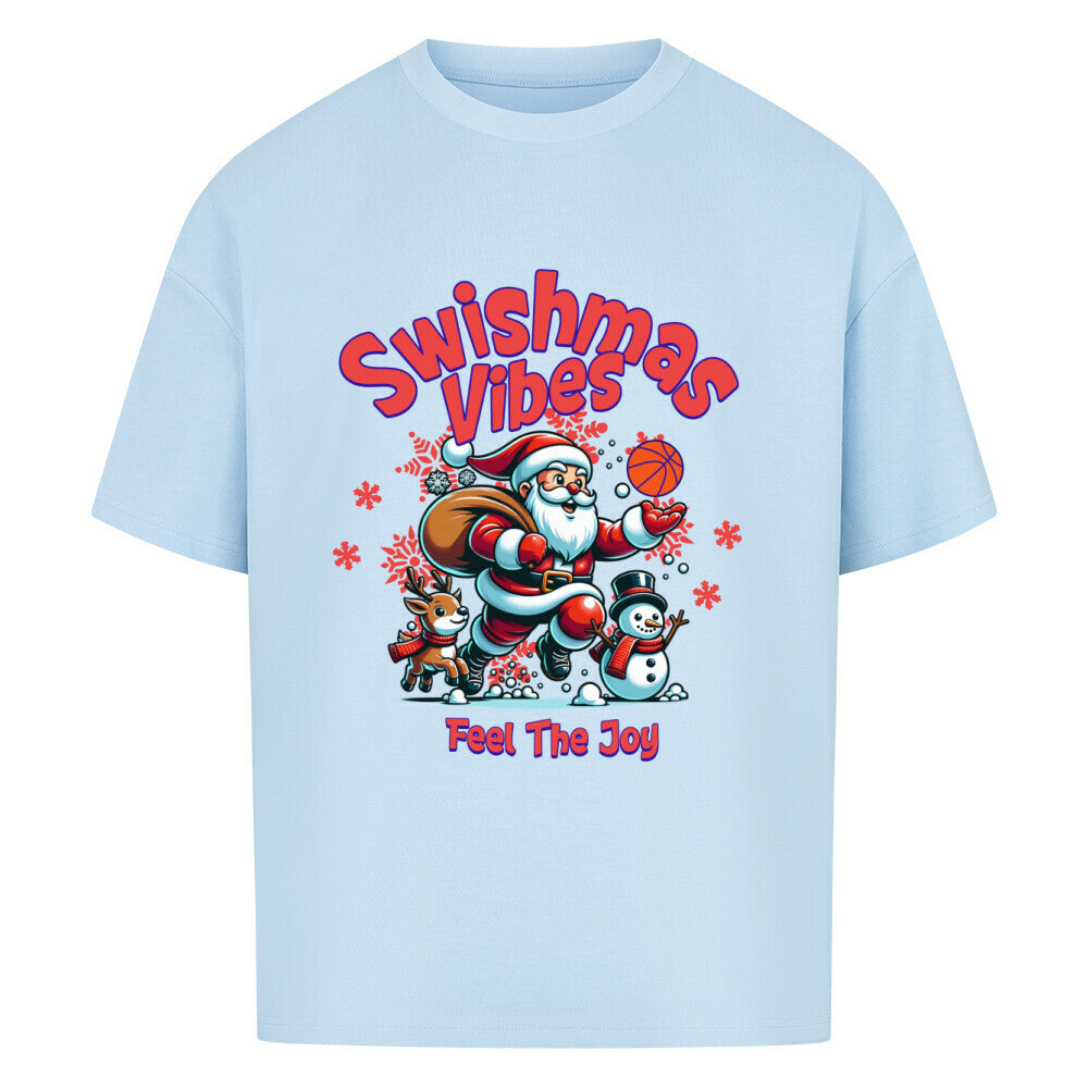 Oversized T-Shirt in Babyblau mit dem Print "Swishmas Vibes Feel The Joy". Das Design zeigt einen fröhlichen Weihnachtsmann (Santa Claus), der einen Basketball in der Hand hält und von einem Rentier und einem Schneemann begleitet wird. Das T-Shirt ist aus 100% Baumwolle und hat einen weiten Schnitt.