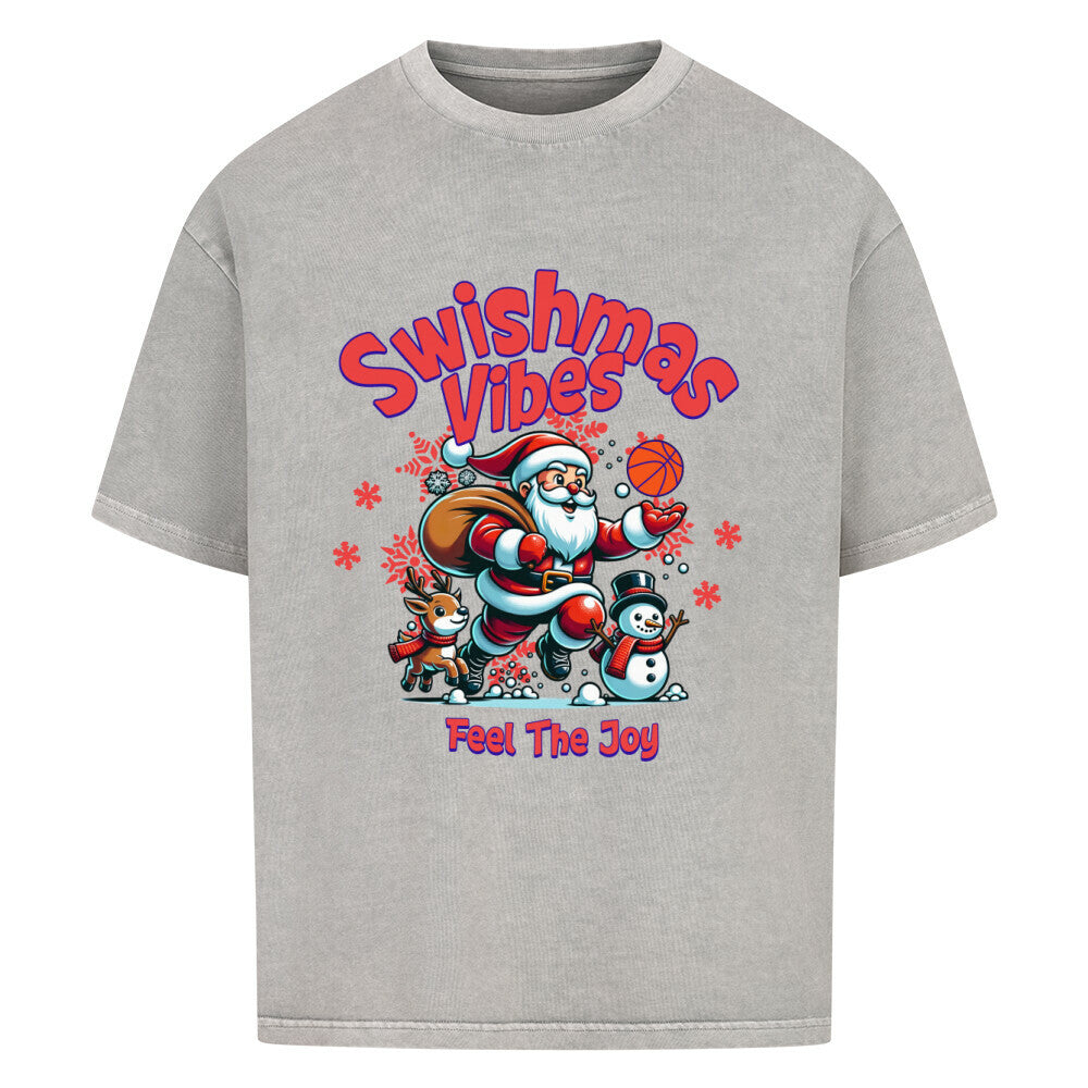 Oversized T-Shirt in Washed Grey mit dem Print "Swishmas Vibes Feel The Joy". Das Design zeigt einen fröhlichen Weihnachtsmann (Santa Claus), der einen Basketball in der Hand hält und von einem Rentier und einem Schneemann begleitet wird. Das T-Shirt ist aus 100% Baumwolle und hat einen weiten Schnitt.