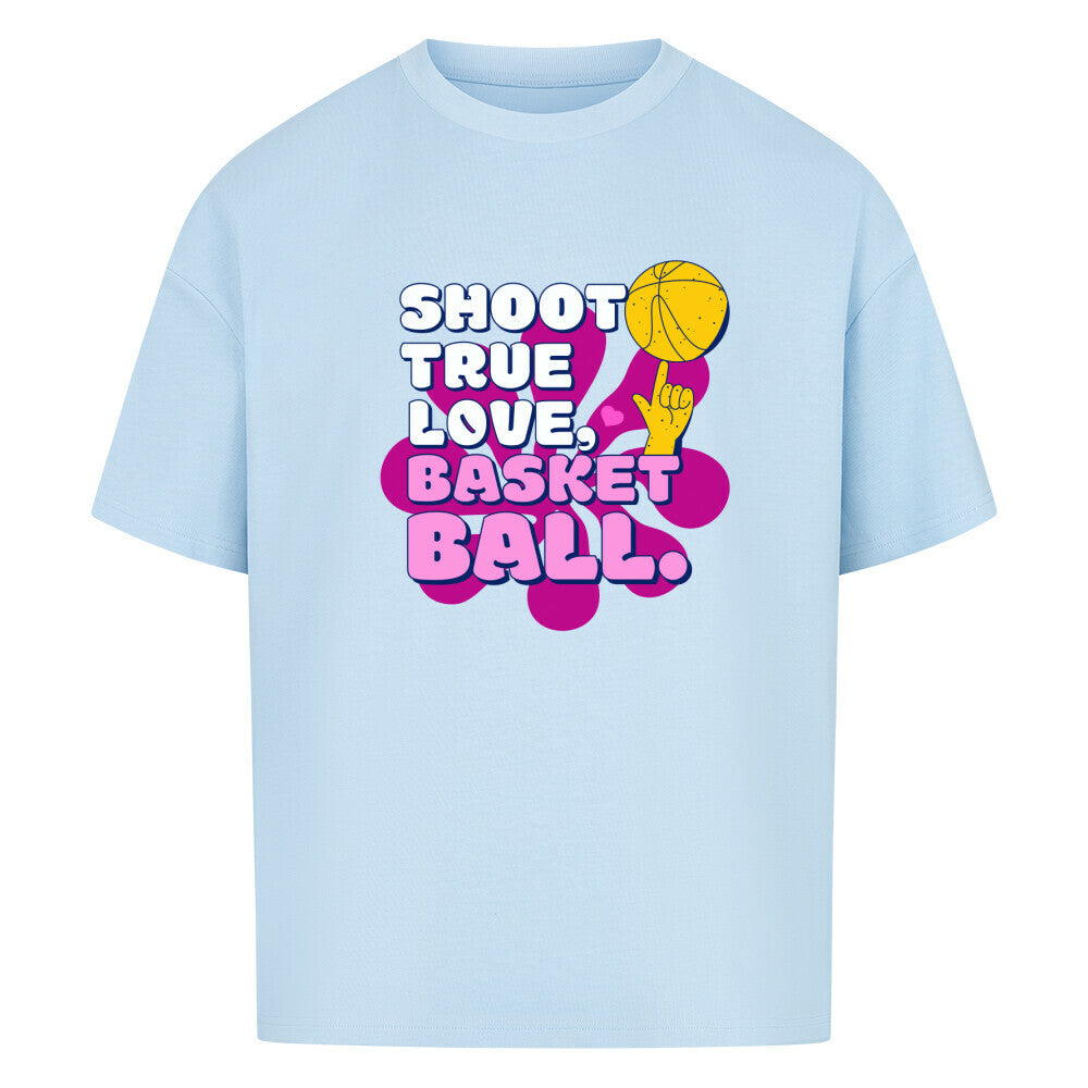 Babyblau Oversized T-Shirt aus 100% Baumwolle mit einem pink-lila Retro-Print. Der Text lautet "SHOOT TRUE, LOVE, BASKETBALL" in Weiß mit dicken Rändern. Das Motiv zeigt einen Basketball und eine Hand.
