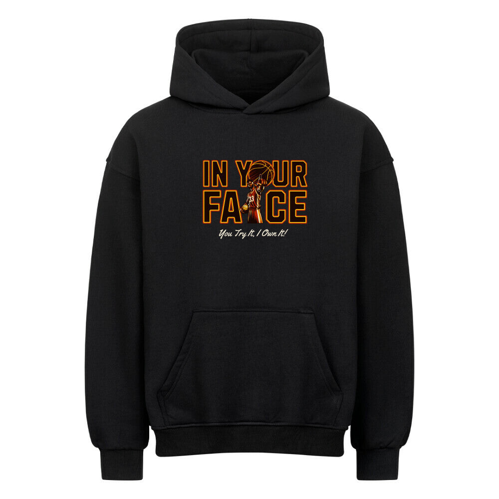Vorderansicht eines schwarzen Oversized-Hoodies mit 'In Your Face' Print, der einen Basketballspieler und den Spruch 'You Try It, I Own It!' zeigt.