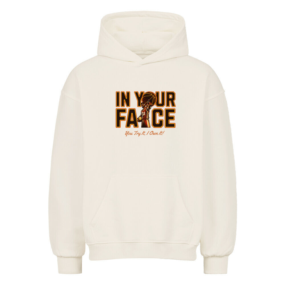 Vorderansicht eines cremefarbenen Oversized-Hoodies mit 'In Your Face' Print, der einen Basketballspieler und den Spruch 'You Try It, I Own It!' zeigt.