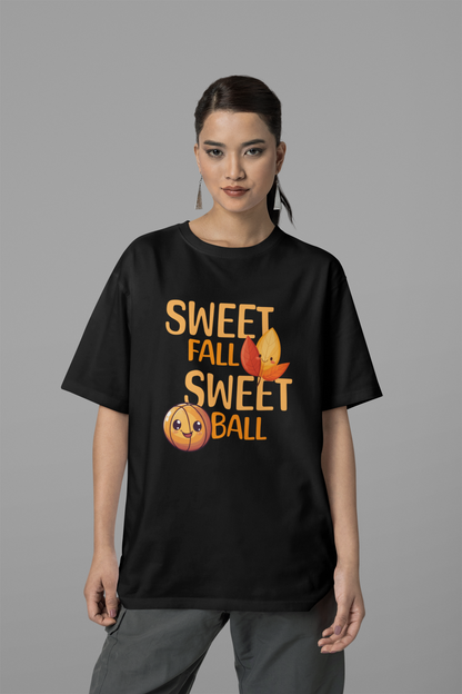 Mockup mit Schwarzen Oversized T-Shirt mit orangefarbenem Print „SWEET FALL SWEET BALL“, verziert mit einem niedlichen lächelnden Basketball und zwei lachenden Herbstblättern – 100% Baumwolle.