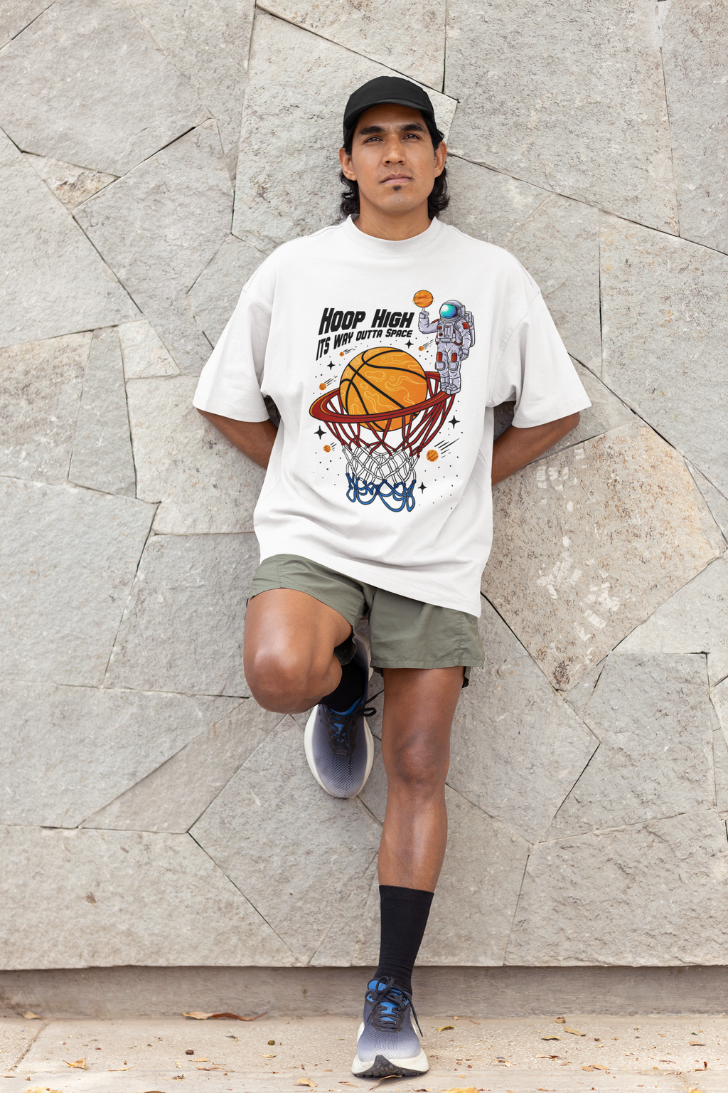 Mockup mit Model Weißes Oversized T-Shirt mit einem bunten Print eines Astronauten im Weltall, der einen Basketball in einen Korb dunkt. Der Slogan lautet: "HOOP HIGH ITS WAY OUTTA SPACE". 100% Baumwolle.